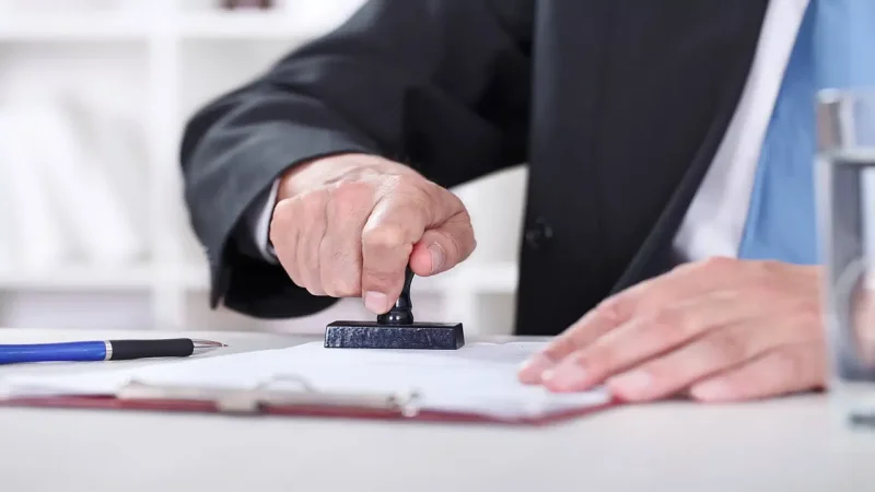 سردفتر در حال مهر کردن و تایید یک مدرک