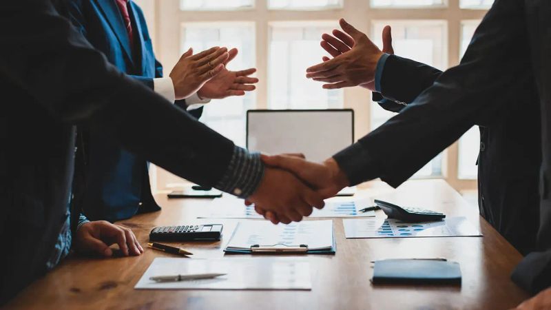 دو نفر درحال دست دادن به هم نمادی از تسهیل معاملات توسط مشاورین املاک